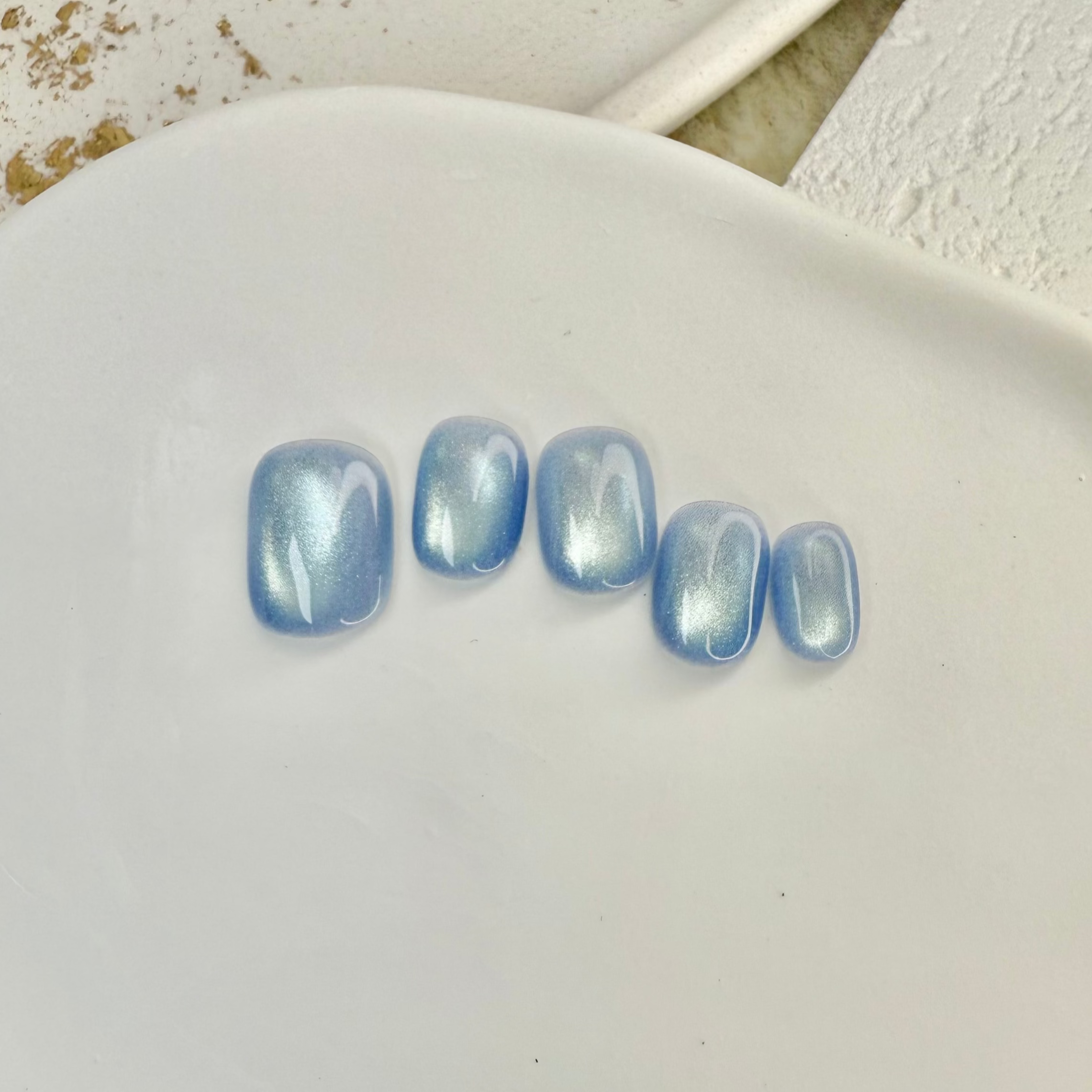 Ocean Whisper cat eye press-on nails in soft blue with magnetic shimmer effect