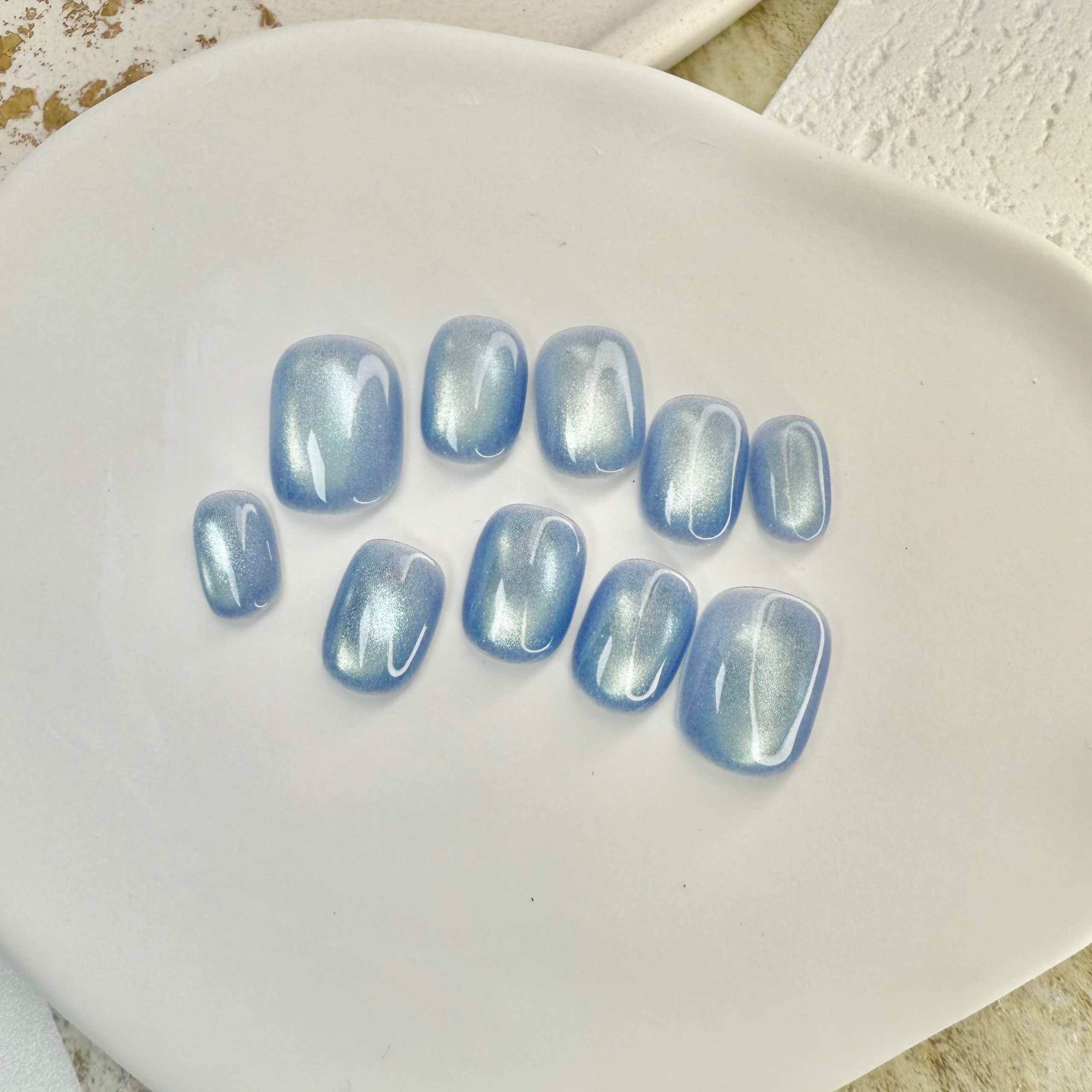 Ocean Whisper cat eye press-on nails in soft blue with magnetic shimmer effect