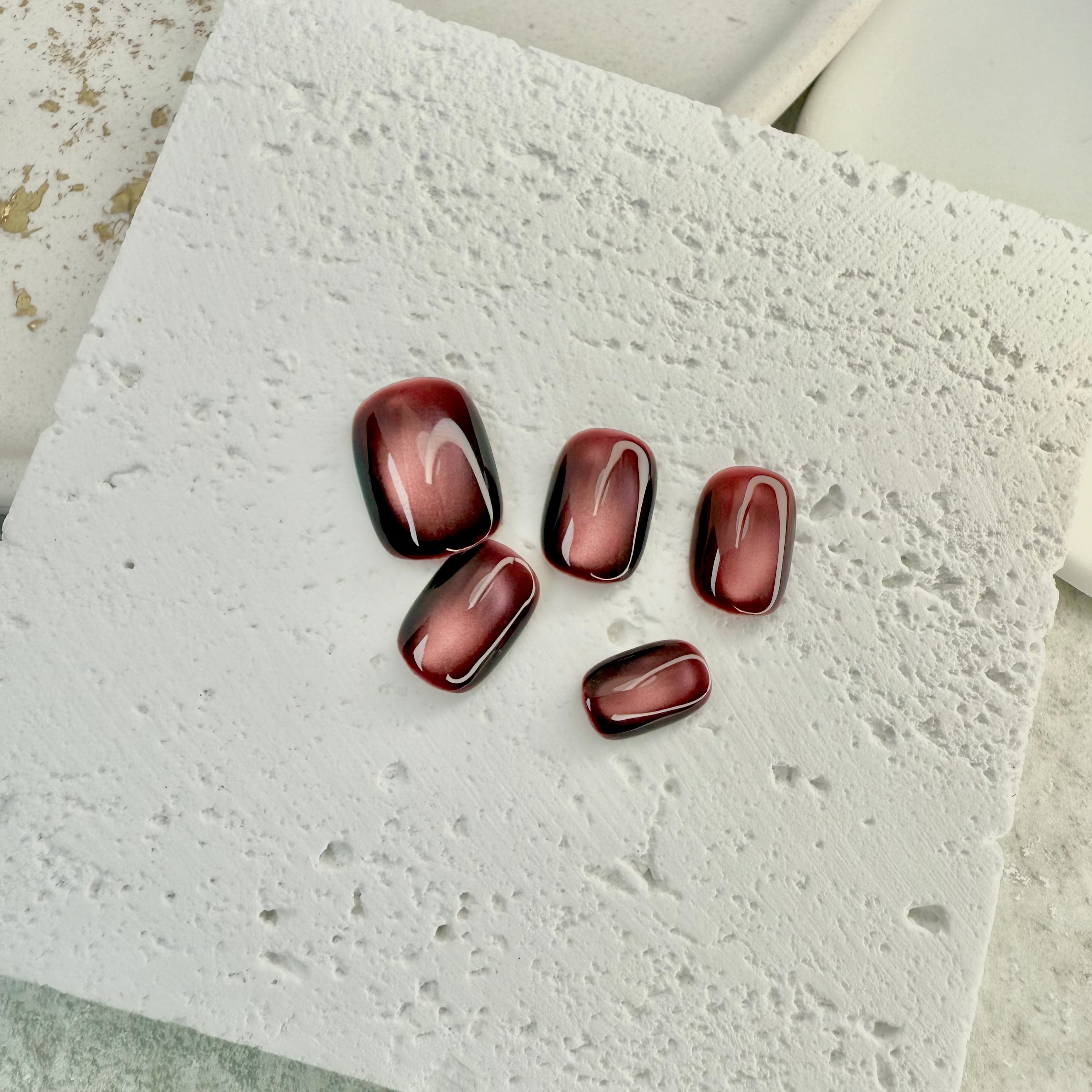 Ruby Mist cat eye press-on nails with deep red shimmer and magnetic glow