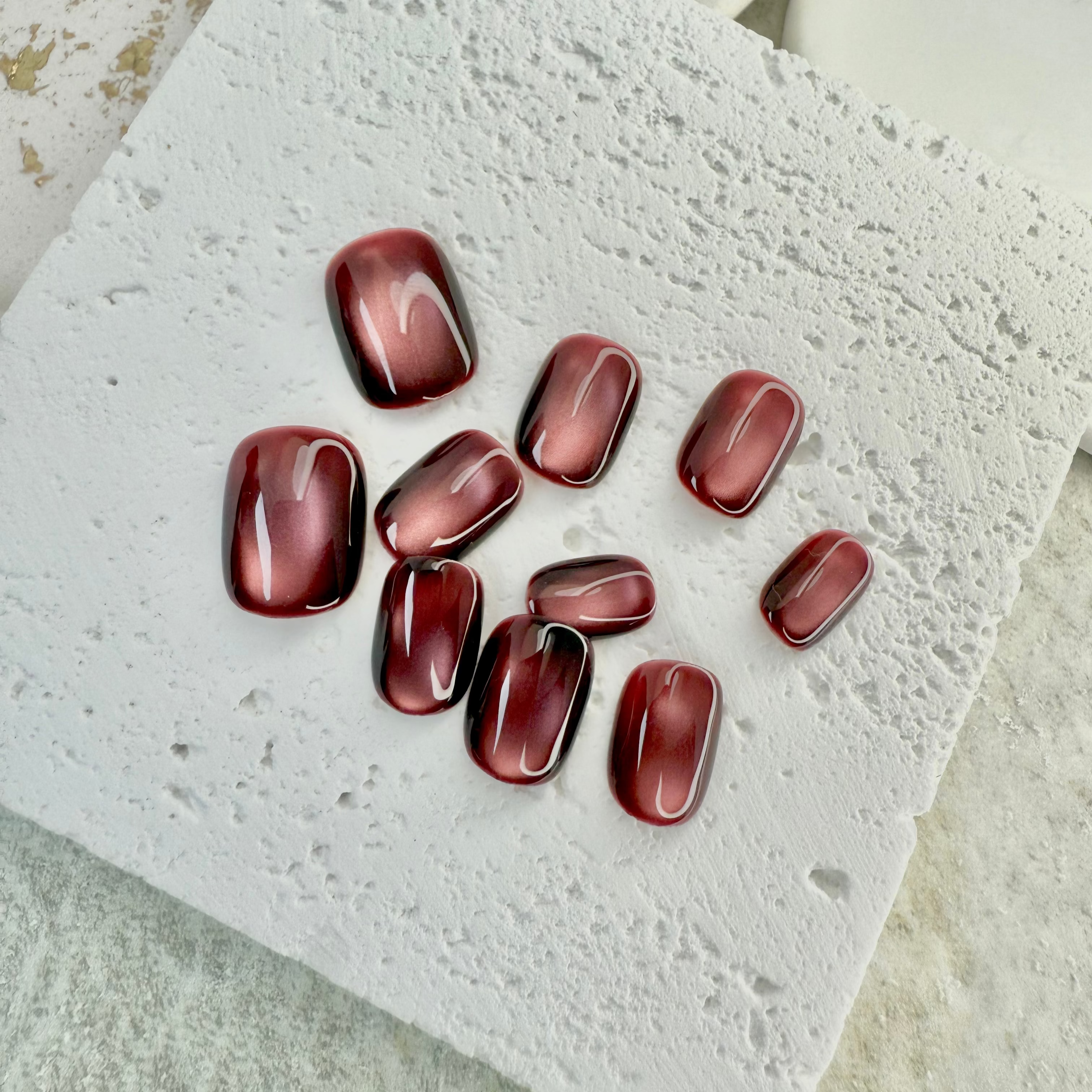 Ruby Mist cat eye press-on nails with deep red shimmer and magnetic glow