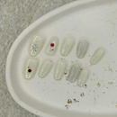 Clear press on nail polish samples on a beige tray with a textured background