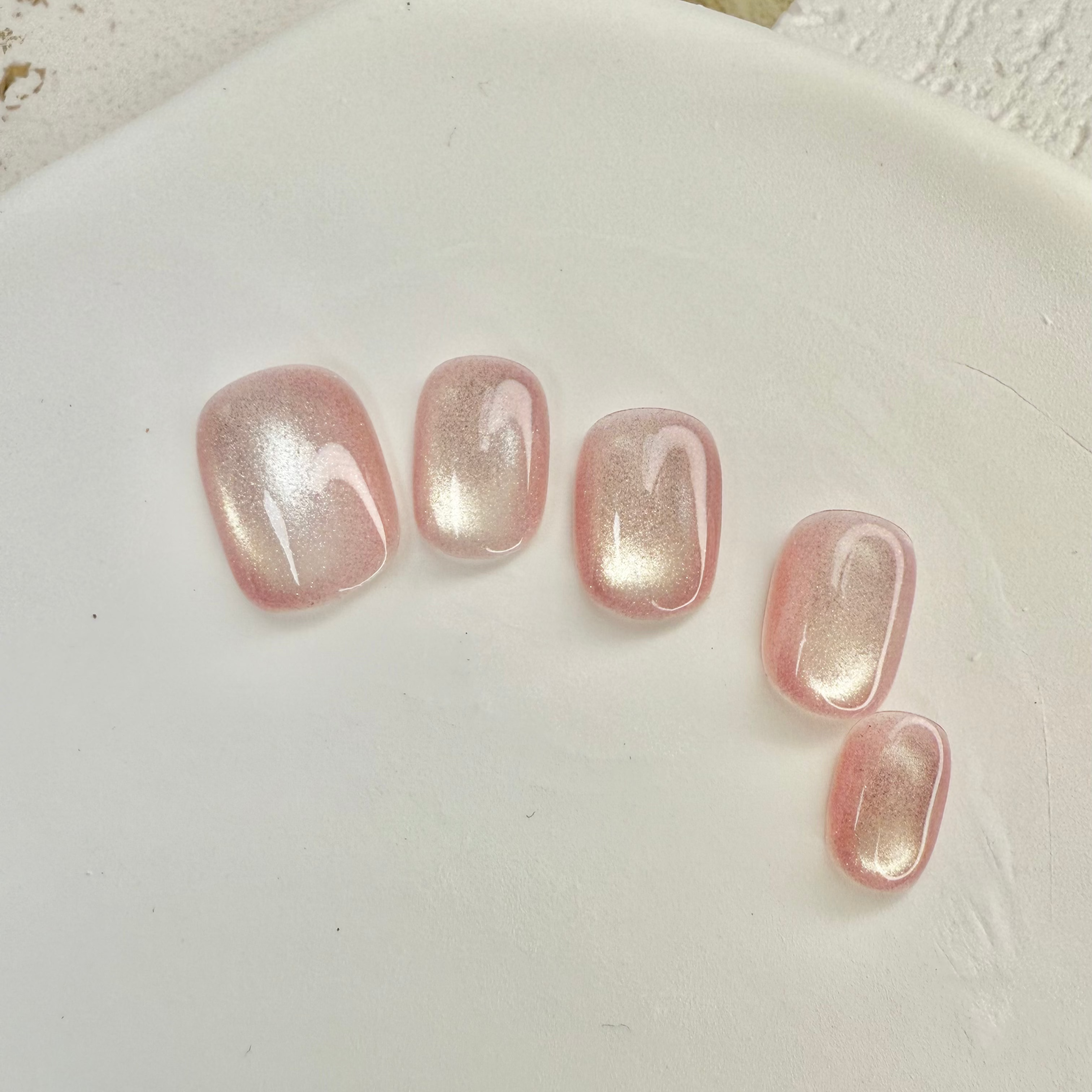 Rose Starlight cat eye press-on nails with soft pink shimmer and magnetic glow