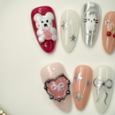 3D jelly bear and ribbon themed press-on nails in silver, pink, and nude tones with stars, cherries, and metallic heart details – handcrafted by Vlei Nails Cape Town.
