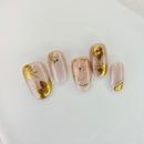 Handcrafted nude and silver press-on nails with 3D gold glitter flower design and metallic shimmer – made by Vlei Nails Cape Town.
