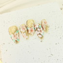 Handcrafted pink cat-eye press-on nails with gold foil and pearl accents, soft shimmer finish – made by Vlei Nails Cape Town.
