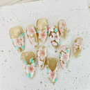 Handcrafted pink press-on nails with gold foil and pearl accents, soft shimmer finish – made by Vlei Nails Cape Town.
