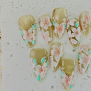 Handcrafted pink press-on nails with gold foil and pearl accents, soft shimmer finish – made by Vlei Nails Cape Town.
