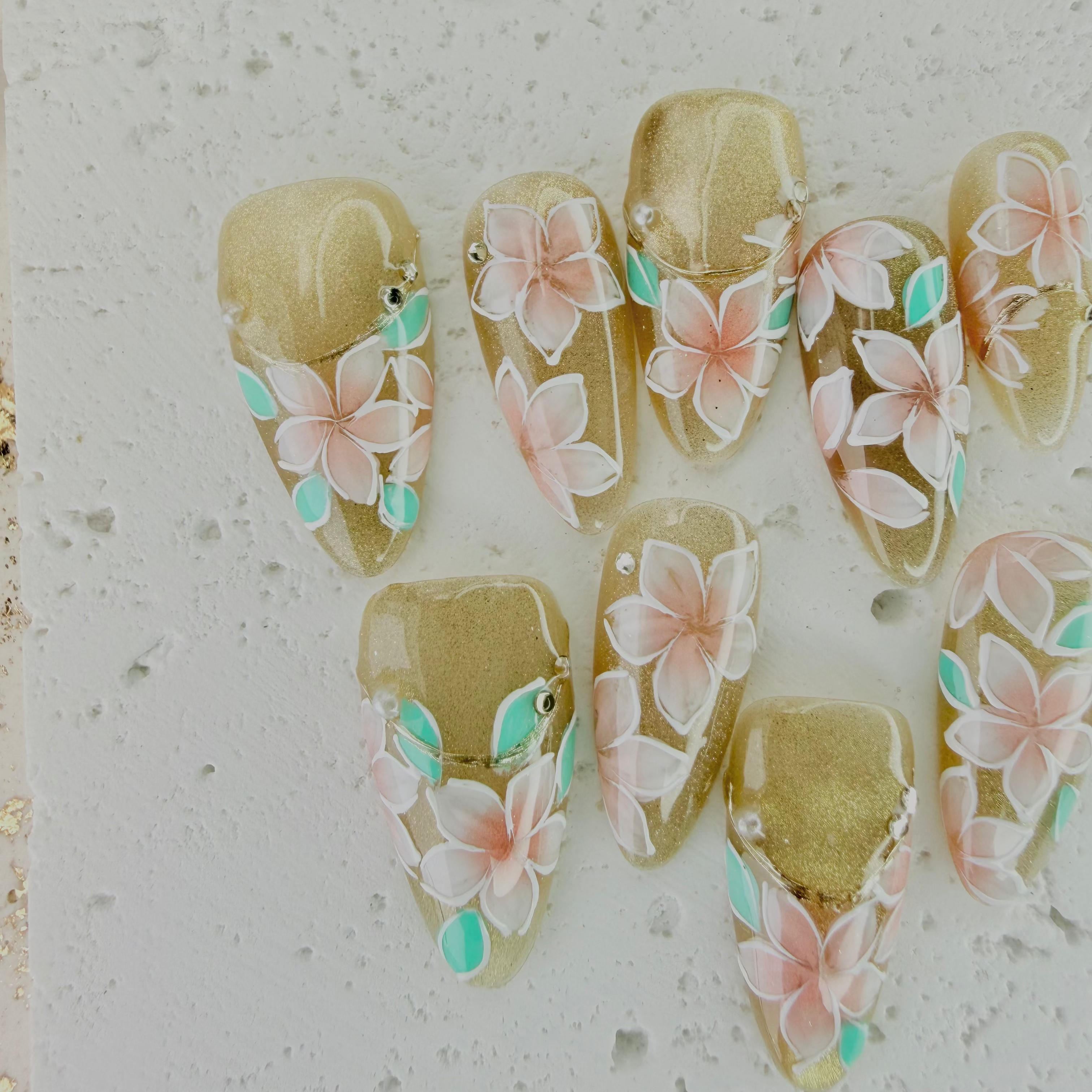 Handcrafted pink press-on nails with gold foil and pearl accents, soft shimmer finish – made by Vlei Nails Cape Town.
