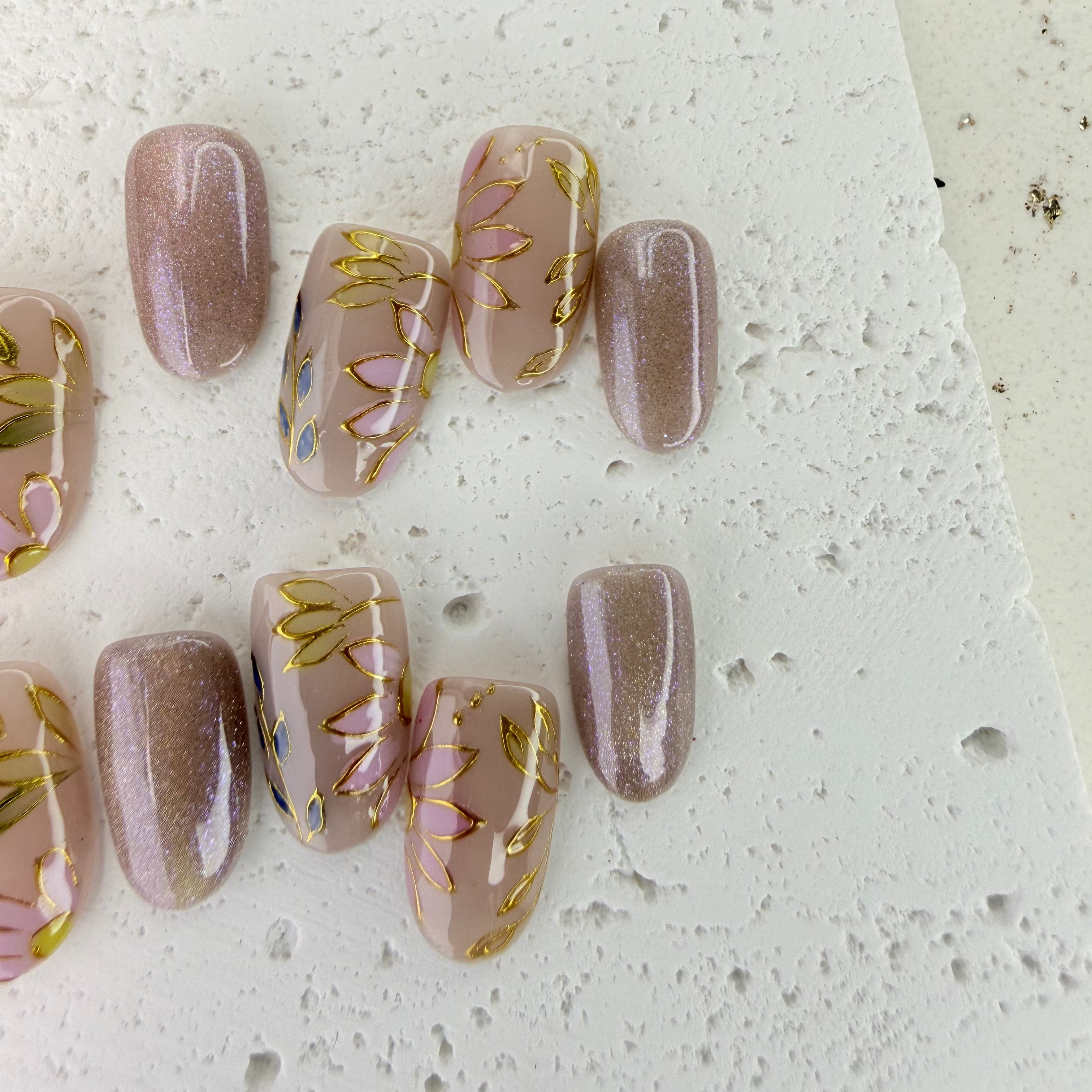 Handcrafted nude pink and gold cat-eye press-on nails with 3D gold line accents – made by Vlei Nails Cape Town.

