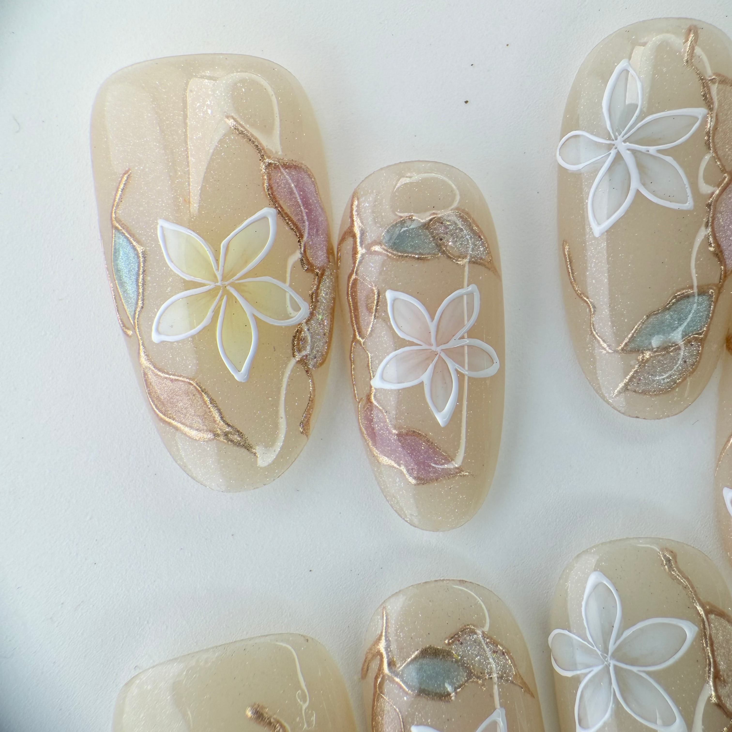 Handcrafted blush nude press-on nails with pearl flowers and gold shimmer lines – made by Vlei Nails Cape Town.
