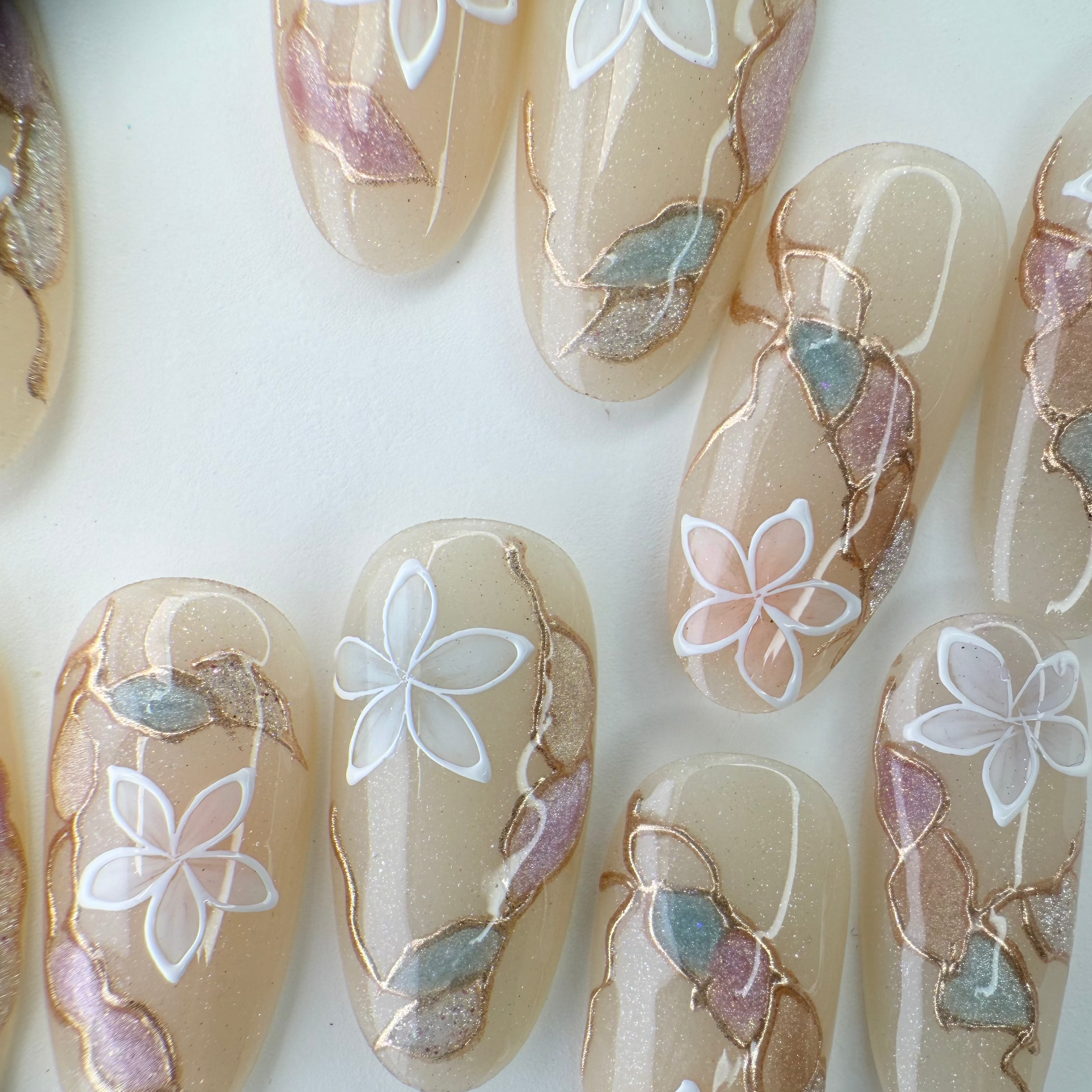 Handcrafted blush nude press-on nails with pearl flowers and gold shimmer lines – made by Vlei Nails Cape Town.
