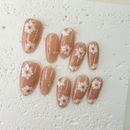 Handcrafted nude pink press-on nails with 3D pearl flowers and gold foil shimmer – made by Vlei Nails Cape Town.
