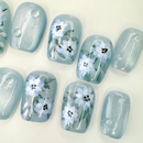 Handcrafted blue press-on nails with 3D white flowers and silver shimmer – made by Vlei Nails Cape Town.
