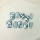 Handcrafted blue press-on nails with 3D white flowers and silver shimmer – made by Vlei Nails Cape Town.
