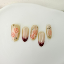 Handcrafted nude press-on nails with red French tips and 3D pink rose accents – made by Vlei Nails Cape Town.
