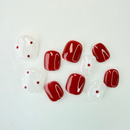 Red and white kiddies press-on nails with glossy finish and tiny polka dot accents on a white background.