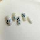Green floral press-on nails with white 3D flowers and silver accents.
