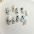 Green floral press-on nails with white 3D flowers and silver accents.
