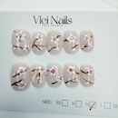 Cherry blossom floral press-on nails on milky nude base, short round.