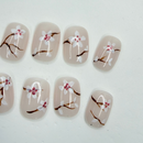 Cherry blossom floral press-on nails on milky nude base, short round.