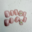 Blush pearl shimmer press-on nails with 3D white flower accents, short round