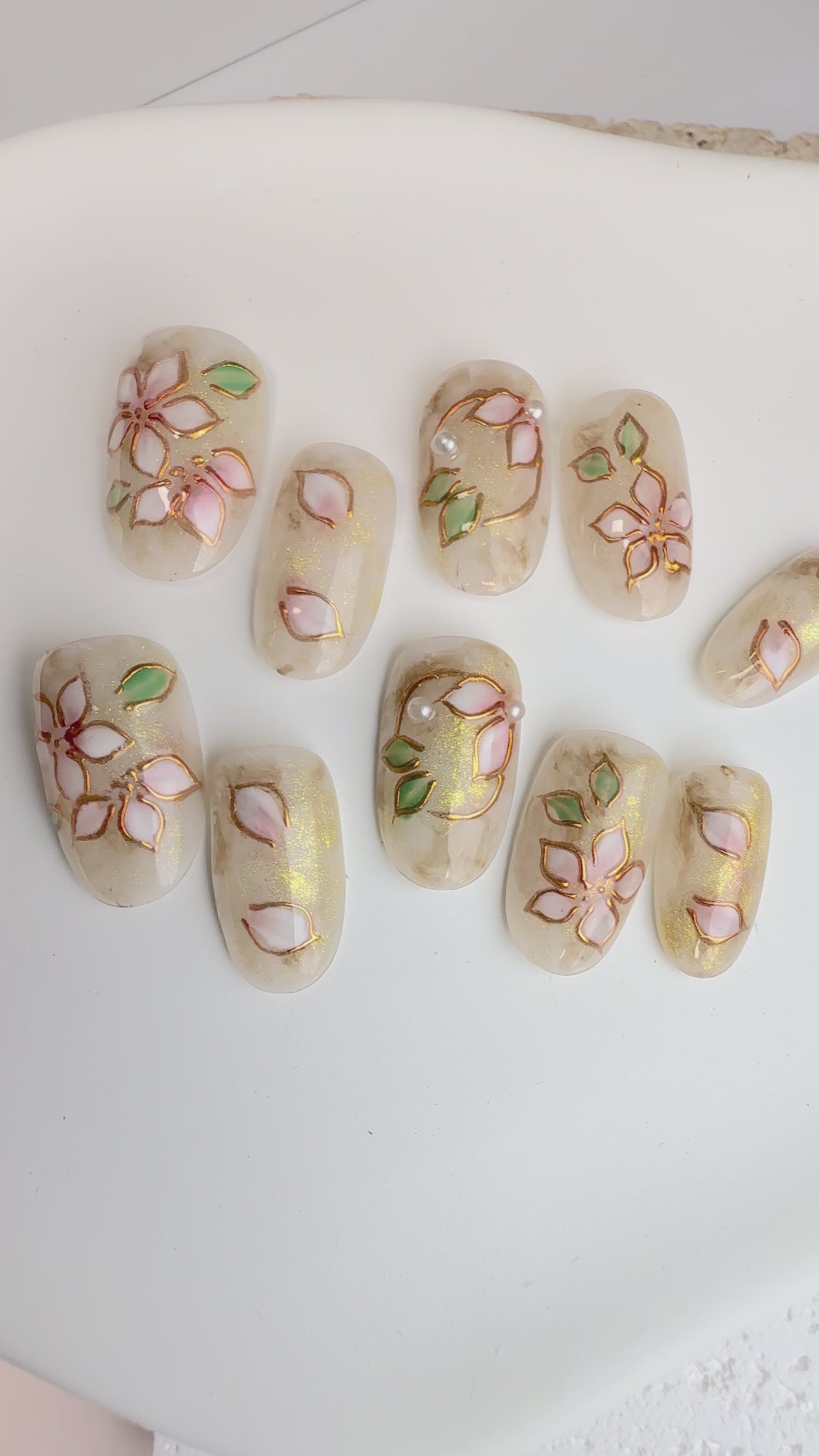 Frosty  press-on nails with white 3D flowers, gold lines and marble accents.