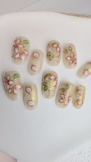 Frosty  press-on nails with white 3D flowers, gold lines and marble accents.