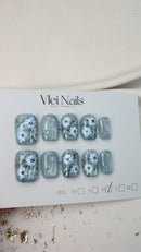 Handcrafted blue press-on nails with 3D white flowers and silver shimmer – made by Vlei Nails Cape Town.
