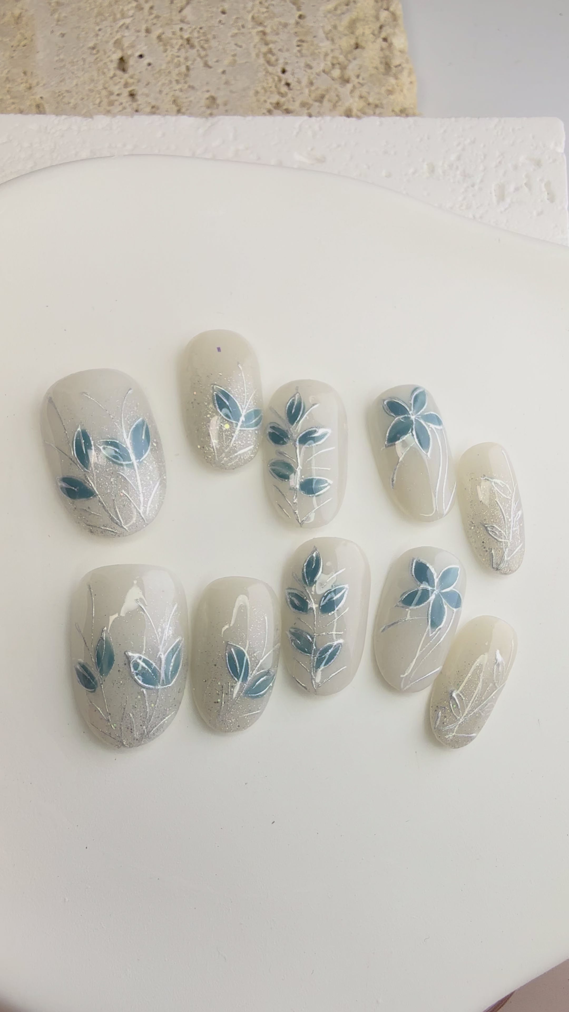 Green floral press-on nails with white 3D flowers and silver accents.
