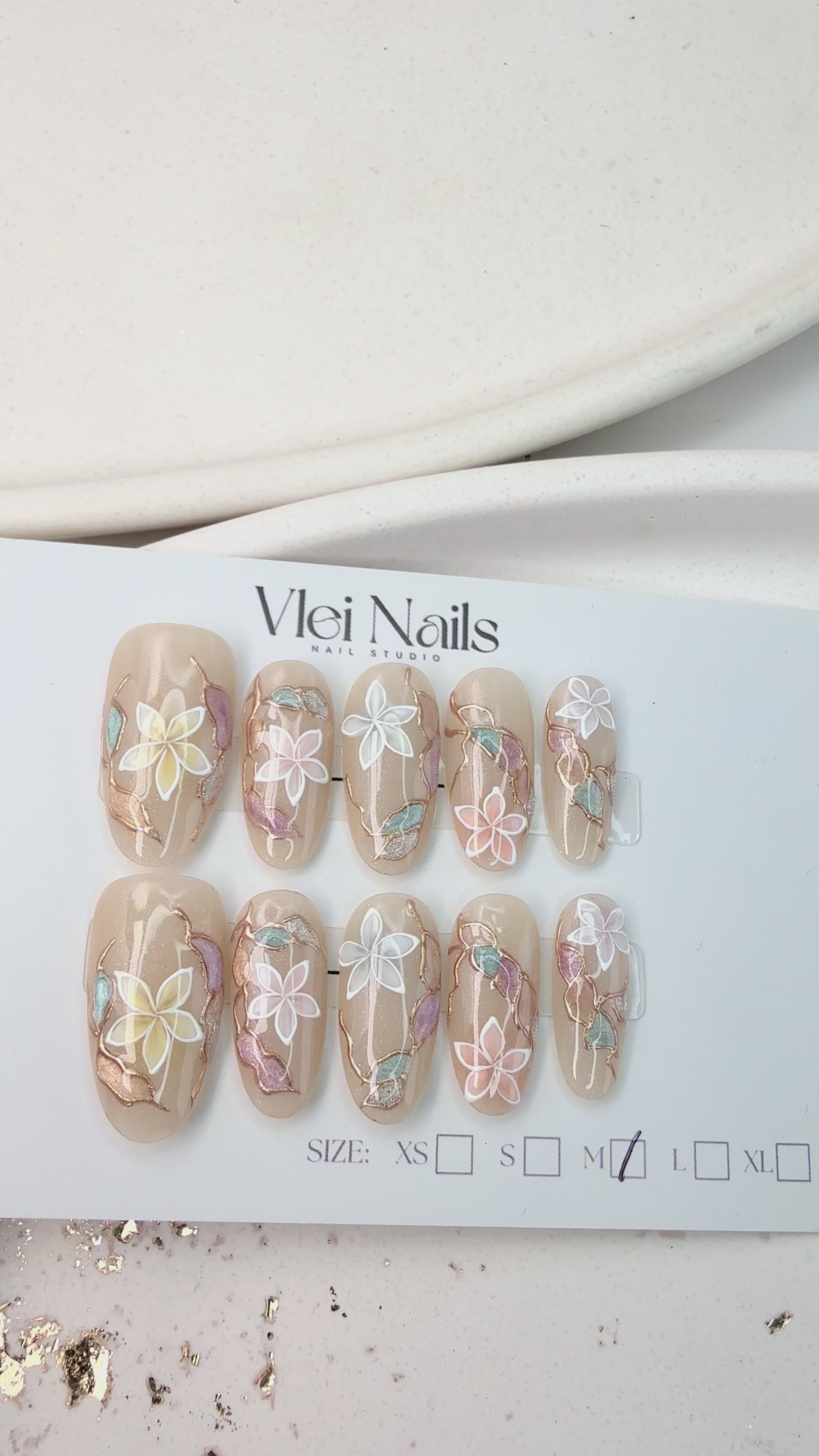 Handcrafted blush nude press-on nails with pearl flowers and gold shimmer lines – made by Vlei Nails Cape Town.
