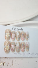 Handcrafted blush nude press-on nails with pearl flowers and gold shimmer lines – made by Vlei Nails Cape Town.

